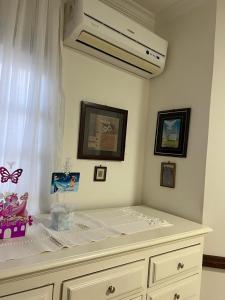 a bedroom with a bed with a white dresser at Quarto privativo em casa domiciliar in Campo Grande