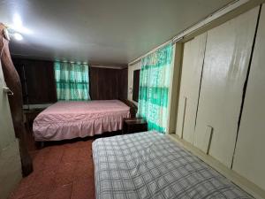 a small room with two beds and a window at Las Casitas de Playa Pochote. in Pochote