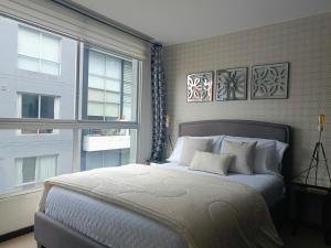 Un dormitorio con una cama grande y una ventana en Like a Home with Balcony - 7Th FLOOR - Parking - Gym, en Quito