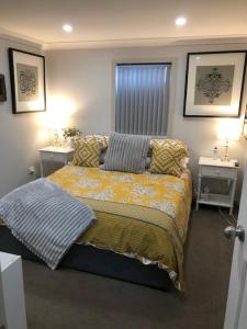 a bedroom with a bed and two night stands at Water Street - Garden Views in Forster