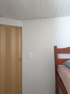Un dormitorio con una puerta y una cama. en Duplex com dois Quartos, en Salvador