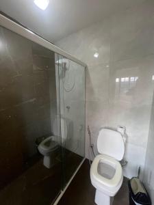 a bathroom with a toilet and a shower and a sink at Pousada Recanto do Canário 2 in Governador Celso Ramos