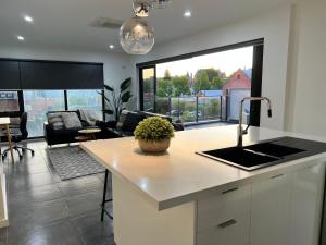 a kitchen with a sink and a living room at Inner City Pad in Ballarat