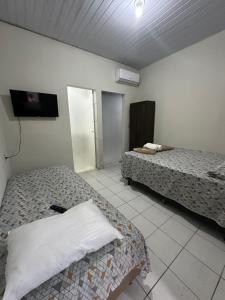 um quarto com 2 camas e uma televisão de ecrã plano em Flat Davisis 4 - Rodoviária Faculdades e Aeroporto em Palmas