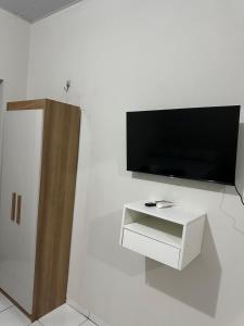 ein Wohnzimmer mit Fernseher und weißer Wand in der Unterkunft Flat Davisis 4 - Rodoviária Faculdades e Aeroporto in Palmas