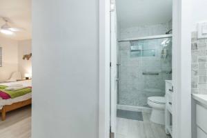 a bathroom with a shower and a toilet and a bed at Summer By The Sea 2 in Pompano Beach