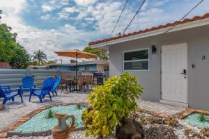 a patio with blue chairs and a table with an umbrella at Summer By The Sea 2 in Pompano Beach