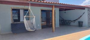a hammock hanging on a porch of a house at Casa de Temporada no Paraíso de Arraial do Cabo in Arraial do Cabo