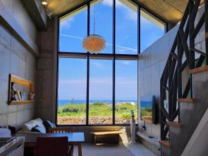a large window in a room with a view of the ocean at Dalthor Pension in Jeju