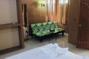 sala de estar con sofá verde y mesa en Lamina Repoq Hiils, en Kuta Lombok