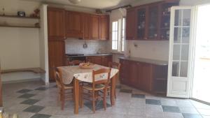 a kitchen with a table and chairs and a kitchen with wooden cabinets at Casa Leoni Capoliveri Isola d'Elba in Capoliveri