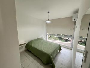 Un dormitorio con una cama verde y una ventana en Dpto Duplex a metros de la Terminal en Salta