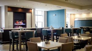a restaurant with tables and chairs and a bar at Holiday Inn Jackson NW - Airport Road, an IHG Hotel in Jackson