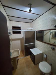 uma casa de banho com um WC e um lavatório em ÉCOisa de Chácara - Casa de Vidro, Casa de Campo em Morretes
