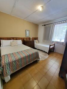 um quarto com uma cama e uma banheira em ÉCOisa de Chácara - Casa de Vidro, Casa de Campo em Morretes