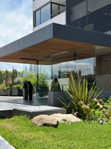 un gran edificio con ventanas de cristal y algunas plantas en Lujoso departamento en Guaymallén