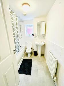 ein weißes Bad mit einem WC und einem Waschbecken in der Unterkunft 3 Bedroom Affordable Family Detached House - Business Contractors, Midlands Location - Private garden,Free car park,TV- Netflix and Free WiFi in Coventry