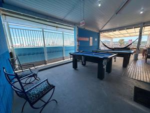 a room with two ping pong tables and a bench at Ilha azul hospedagem in Florianópolis