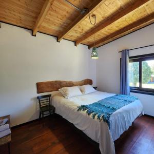 1 dormitorio con cama y techo de madera en k10lodge, en Curacautín