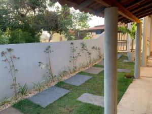 a white fence with stepping stones in a yard at AP a 200m da praia, centro BG in Barra Grande