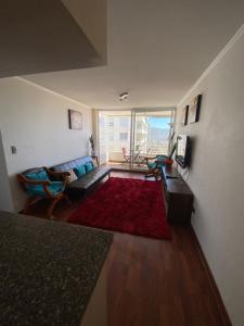 sala de estar con sofá y alfombra roja en Departamento en Valparaíso, en Valparaíso