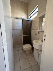 a bathroom with a toilet and a sink at Ilha azul hospedagem in Florianópolis