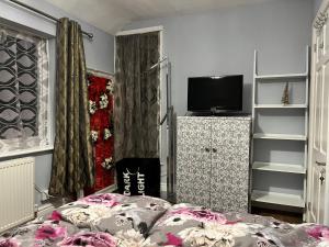 a bedroom with a bed and a flat screen tv at Tinky's Residence in Birmingham