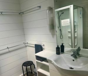 a white bathroom with a sink and a mirror at The Bach at Te Toki in Palm Beach