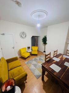 sala de estar con sofá amarillo y mesa en Baravaggio By Kasar Stays en Leicester