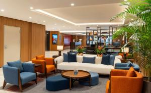 - un hall avec un canapé blanc et des chaises orange dans l'établissement Crowne Plaza Istanbul - Ortakoy Bosphorus, an IHG Hotel, à Istanbul