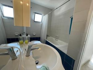 a bathroom with a sink and a bath tub at Pissouri Beach Apartments in Pissouri +37 photos