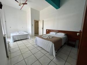 1 dormitorio con 2 camas y techo en Ilha azul hospedagem, en Florianópolis