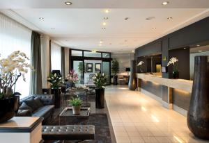 ハンブルクにあるPark Hotel Hamburg Arenaのソファとテーブルのあるホテルのロビー
