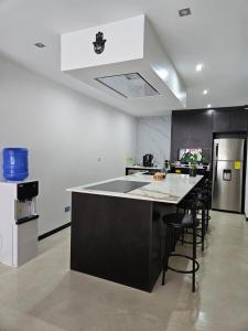 a kitchen with a black and white counter and chairs at Urbanizacion privada "El Sol", Villa K2 in Machala
