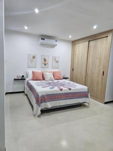 a bedroom with a large bed and a wooden door at Urbanizacion privada "El Sol", Villa K2 in Machala