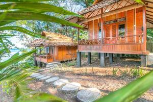 ein Holzhaus mit einer Veranda und einem Balkon in der Unterkunft Raja Laut Dive Resort Bunaken in Bunaken