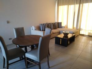sala de estar con sofá, mesa y sillas en Apartamentos mar alta living en Cabo San Lucas