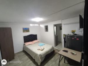 Dormitorio pequeño con cama y mesa en cerca a embajada americana Corferias centro club militar 201, en Bogotá