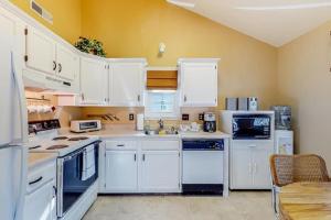 a white kitchen with white appliances and a table at Ocean City Townhome by Beach Bayside in Ocean City