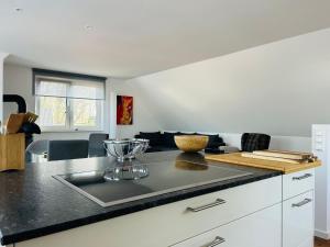 a kitchen with a black counter top and a kitchen island at House Water Jieper near the beach in Göhren-Lebbin