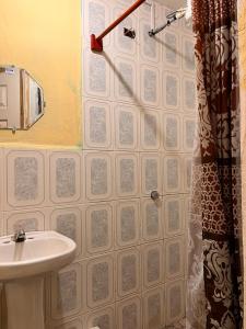 baño con lavabo y cortina de ducha en Hotel Canaan La aurora, en Guatemala