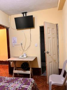 Habitación con escritorio y TV en la pared. en Hotel Canaan La aurora, en Guatemala