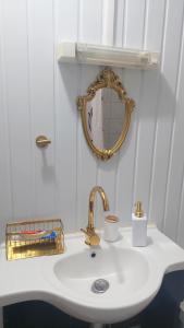 a bathroom sink with a gold faucet and a mirror at Dolce Pace Kreyol in Cayenne +40 photos