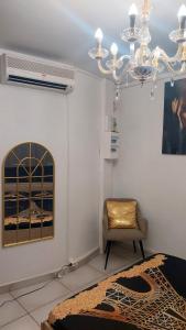 a living room with a chair and a chandelier at Dolce Pace Kreyol in Cayenne