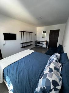 佛羅安那波里的住宿－Pousada tamatoa，一间卧室配有一张带蓝色棉被的床