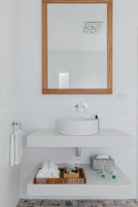 La salle de bains est pourvue d'un lavabo, d'un miroir et de serviettes. dans l'établissement Bay Cottage, à Patonga Beach