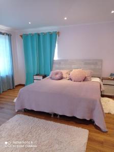 - une chambre avec un grand lit et des rideaux bleus dans l'établissement Casa de montaña San Francisco, à Los Andes