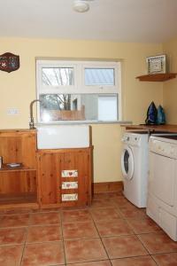 a kitchen with a sink and a washing machine at Biddy Rua's Place in Killybegs