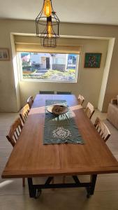 a large wooden table in a room with a large window at CUNCUMEN Caviahue in Caviahue