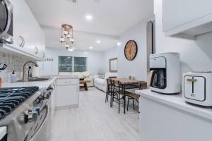 a kitchen with white appliances and a living room at Summer By The Sea 1 in Pompano Beach
